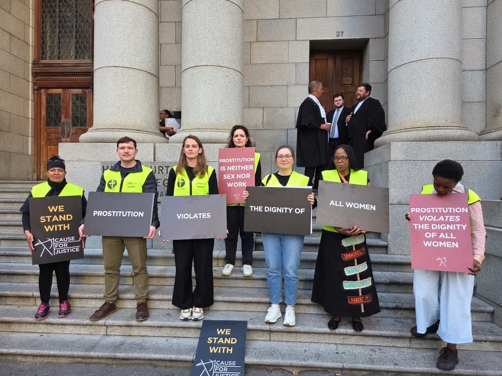 Protestors holding signs in front of court